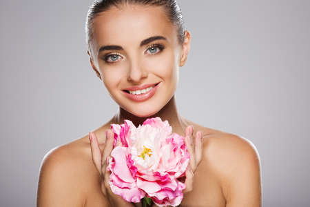 Beauty portrait of model with big pink flowerの写真素材