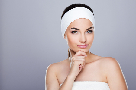 Young woman with white headband thinking about somethingの写真素材
