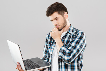 Thoughtful man looking at laptopの写真素材