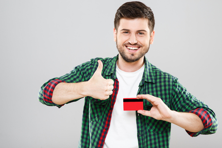 Man holding credit card and showing thumbs upの写真素材