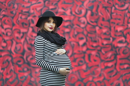 Pregnant woman near colorful wallの写真素材