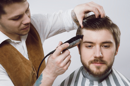 Attractive barber doing haircutの写真素材