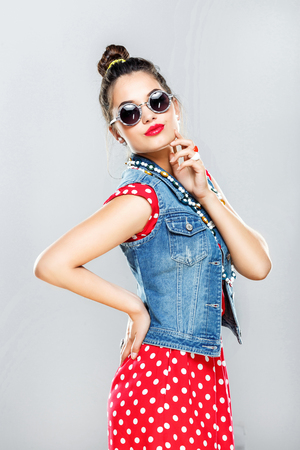 Pretty fashion model posing at gray backgroundの写真素材