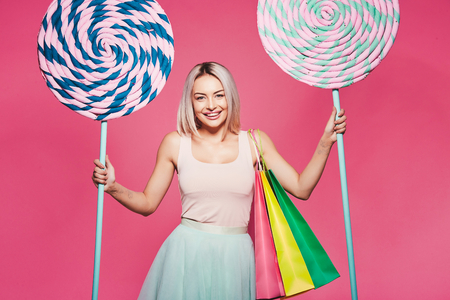 Model posing with with sweets and shopping bagsの写真素材