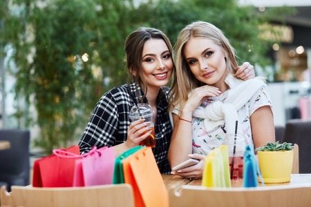 Attractive girls in shopping mall with bagsの写真素材