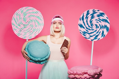 Blonde girl posing with sweetsの写真素材