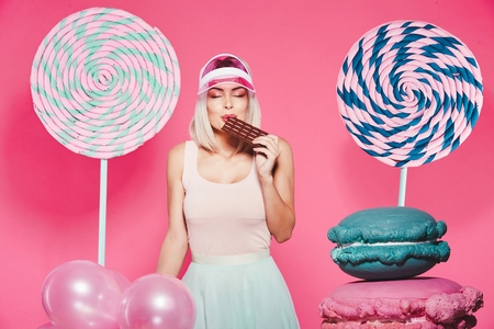 Blonde girl posing with sweetsの写真素材