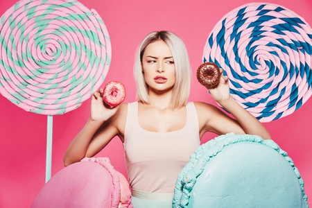 Blonde girl posing with sweetsの写真素材