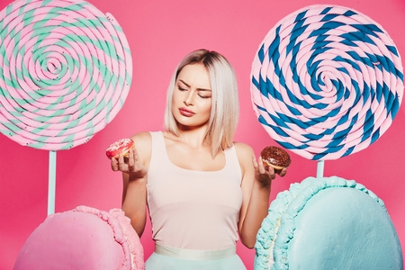 Blonde girl posing with sweetsの写真素材