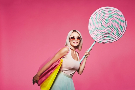 Girl with sweets at pink backgroundの写真素材