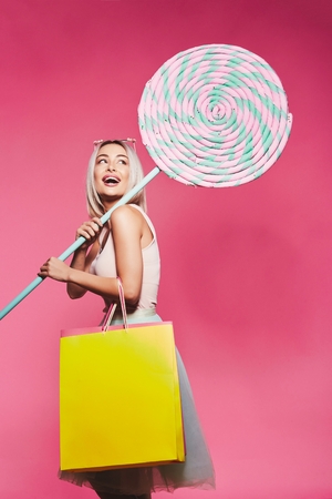 Cute model with sweets and shopping bagsの写真素材