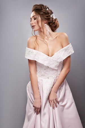 elegant bride touching her dress and looking downの写真素材