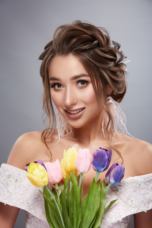 pretty bride smilling with colorful flowersの写真素材