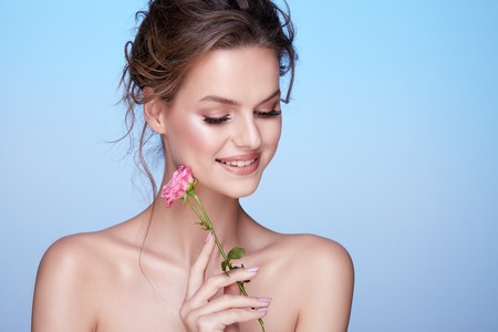 Pretty woman at  studio background with flowersの写真素材
