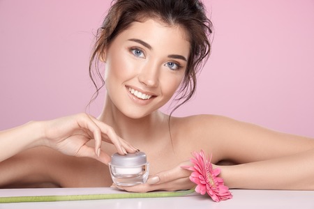 Woman at  pink studio background with flowersの写真素材