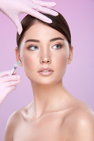 Brunette girl at pink backgroundの写真素材