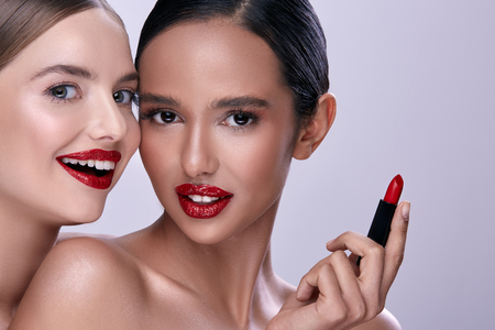 Cute girls posing with red lipstickの写真素材