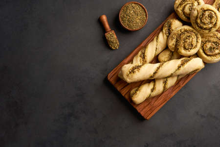 Freshly baked homemade swirls buns and straws with zaatar. Top view with copy space
