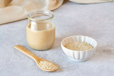 Glass jar with tahini and sesame seedsの写真素材