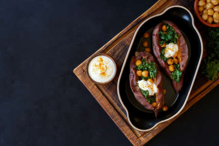 Baked sweet potato filled with kale and chickpeas. Top view with copy space