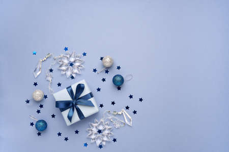Christmas, New year composition. Gift box and holiday decorations on blue background. Flat lay. Top...