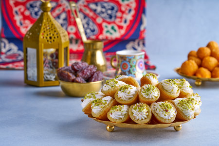 Arabian pancake Qatayef with qishta cream and pistachio . Traditional sweets with ramadan decor