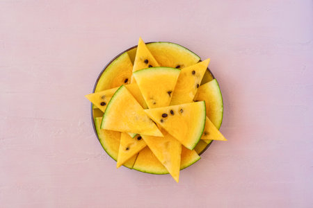 Sliced yellow watermelon on pink background. top viewの写真素材