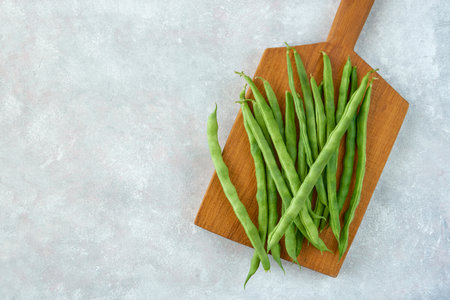 Green common bean on wooden board .Top view with copy space