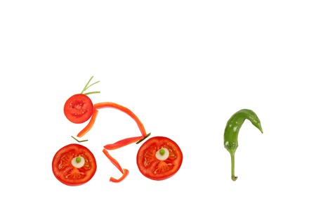 Healthy eating. Funny little man of the pepper slices on a bicycleの写真素材