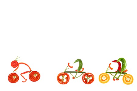 Healthy eating. Four little funny peppers on bicycles.の写真素材