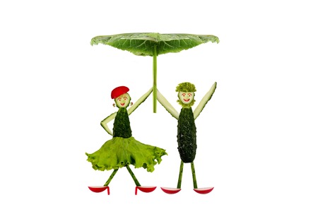 Funny little people made ??of cucumber under an umbrellaの写真素材
