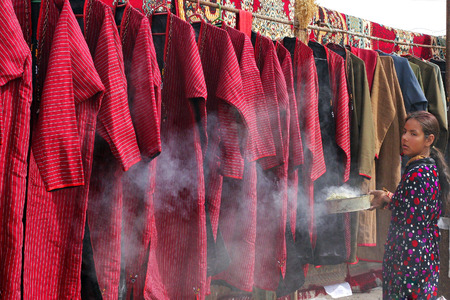 Ashgabat, Turkmenistan - March 09   Portrait of young unidentified  Asian girl  Girl making a rite for the best selling things  Oriental bazaar   Ashgabat, Turkmenistan - March 09  2013  のeditorial素材