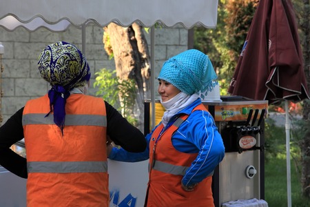 Ashgabat, Turkmenistan - October 26, 2014.  Women clean the streets, having fun talking to each other.   Ashgabat, Turkmenistan - October 26, 2014.のeditorial素材