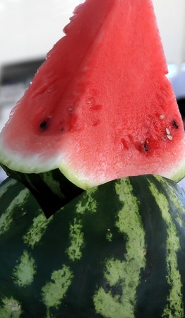 A large slice of watermelon looking out from the middle of the watermelonのeditorial素材