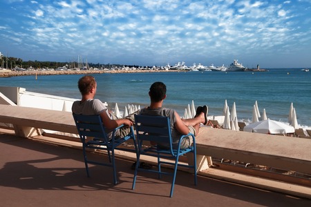 CANNES, FRANCE -  JULY 5, 2014: Two friends relaxing in chairs on Croisette promenade in Cannes, France. CANNES, FRANCE -  JULY 5, 2014:のeditorial素材