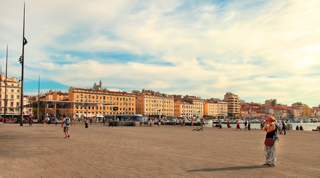 MARSEILLE - JULY 2, 2014: Old port (Vieux-Port) with people walking along the promenade and basilica of Notre-Dame-de-la-Garde on July 2, 2014, Marseille.のeditorial素材