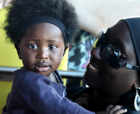 ACCRA, GHANA - July 1, 2014.  Unidentified Ghanaian little baby girl on her mother arms. People of Ghana suffer of poverty due to the difficult economic situationのeditorial素材