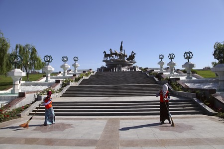Women sweep the area near the monument. Ashgabat, Turkmenistan - October 26, 2014.のeditorial素材