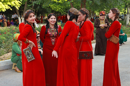 Ashgabat, Turkmenistan - May 25, 2017: Group of smiling female students in red national dresses with embroidery. Ashgabat, Turkmenistan, May 25, 2017.のeditorial素材