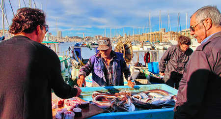 France, Marseille -November 19, 2018: The buyer at the fish market in Marseille.  Old Port of Marseille (Vieux-Port), Marseille is France's largest city on the Mediterranean coast and largest commercial port. October 19, 2018.のeditorial素材