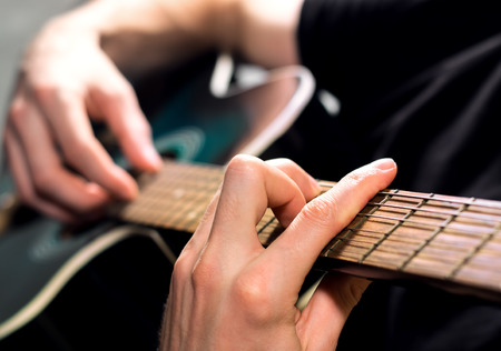 the man guitarist playing on the acoustic guitar