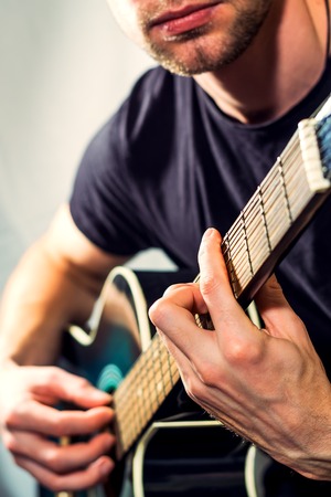 man playing on the acoustic guitar, picture with a light toning