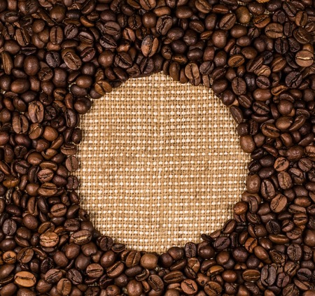 Coffee beans scattered on burlap can be used as backgroundの写真素材
