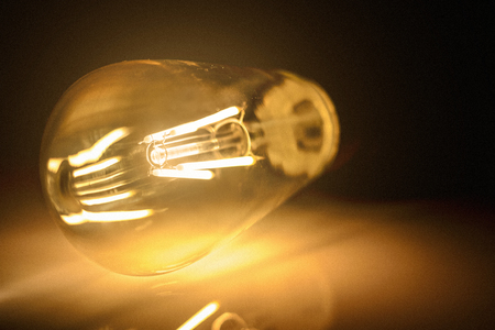 Close-up photo of light bulb on dark background. High quality.