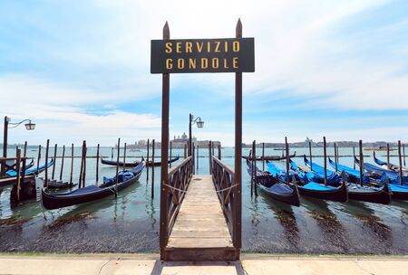 View at Venice lagoon with gondolas and lanterns and San Giorgio Maggiore on background. Italy.の写真素材