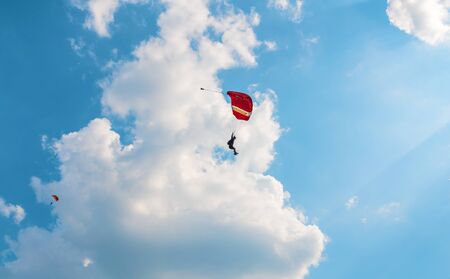 A men flying in the blue sky using parachuteの写真素材