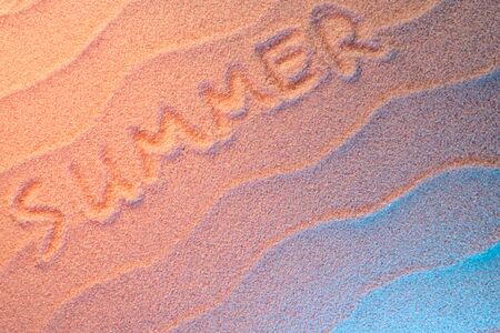 SUMMER lettering on sand with wave and neon light. Minimal exotic vacation and travel concept, Flat lay top view copy spaceの写真素材