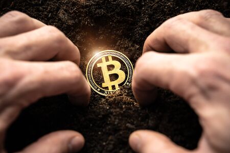 Bitcoin hold concept. Cryptocurrency stored in the ground - saving symbol. A man digs up hidden bitcoins.の写真素材