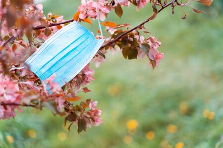 Stop Coronavirus pandemic symbol. defeating the virus idea. T Anti-virus medical mask and spring red flowers. Covid-19 victory concept.の写真素材