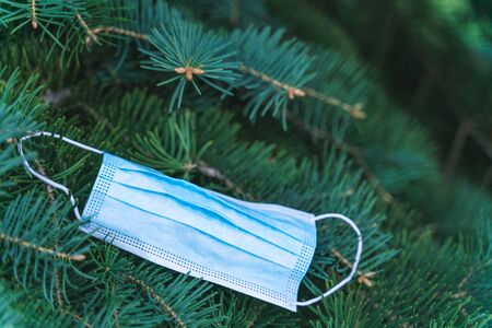 Covid-19 victory concept. Anti-virus medical mask on a coniferous tree. Stop Coronavirus pandemic symbol. defeating the virus idea.の写真素材